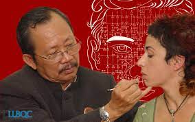 le professeur Bùi Quôc Châu stimule un point sur le visage d'une femme